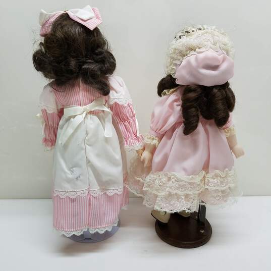 Lot of 2 vintage porcelain brown hair dolls in pink outfits image number 5