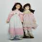 Lot of 2 vintage porcelain brown hair dolls in pink outfits image number 4