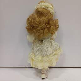 Dynasty Doll Collection Porcelain (Music Box Inside) Doll With Blonde Curly Hair, Blue Eyes, And Yellow Outfit alternative image