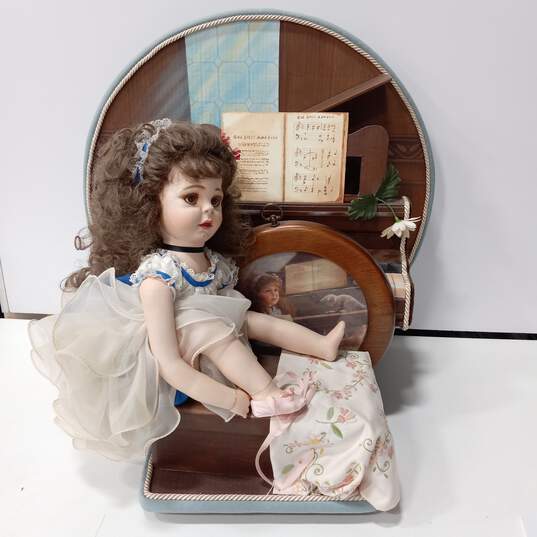 Vintage Doll Sitting On Bench Next To Piano image number 1