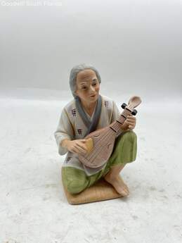 Man With Musical Instrument Figurine