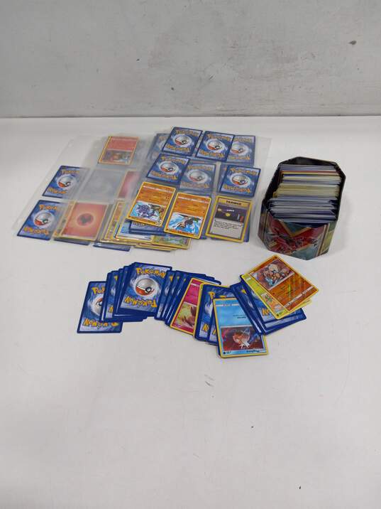 Bundle of Assorted Pokémon Cards In Tin & Sleeves image number 1