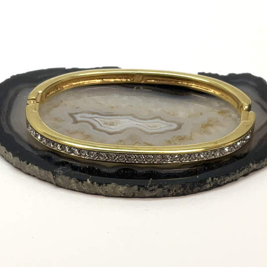 Designer Swarovski Gold-Tone White Rhinestone Hinged Bangle Bracelet image number 1