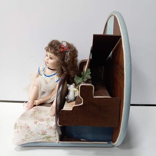 Vintage Doll Sitting On Bench Next To Piano image number 2