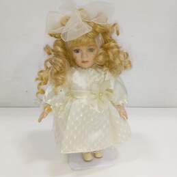 Porcelain doll, blonde, white dress, on stand