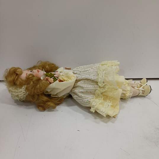 Dynasty Doll Collection Porcelain (Music Box Inside) Doll With Blonde Curly Hair, Blue Eyes, And Yellow Outfit image number 5