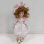 Dynasty Doll Collection Porcelain Doll With Strawberry Blonde Curly Hair And Brown Eyes In Pink Outfit image number 1