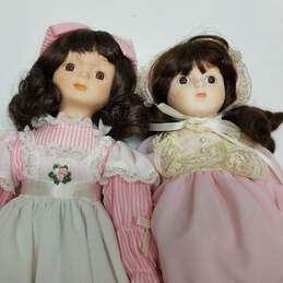 Lot of 2 vintage porcelain brown hair dolls in pink outfits