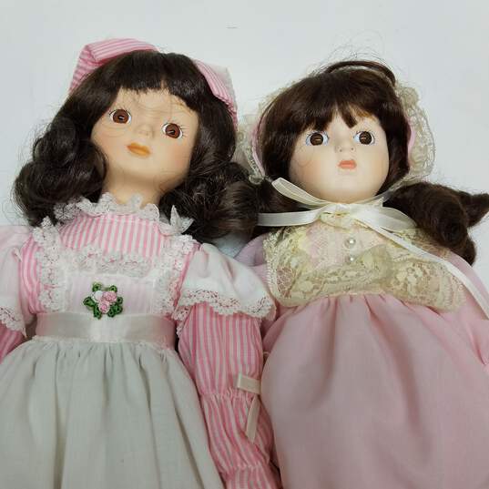 Lot of 2 vintage porcelain brown hair dolls in pink outfits image number 1