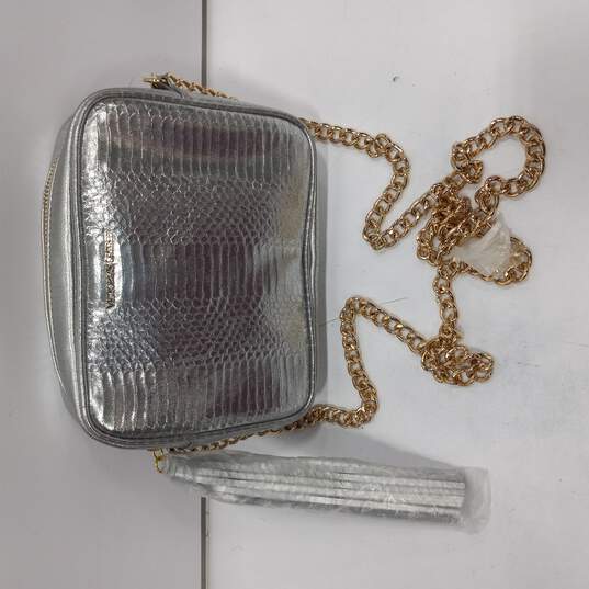 Buy the Victoria's Secret Silver Crossbody Clutch Bag with Gold Chain Strap  and Tassel Zipper Pull