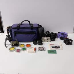 Bundle of 4 Assorted Cameras, Lenses, Flashes & Accessories In Purple Carrying Case