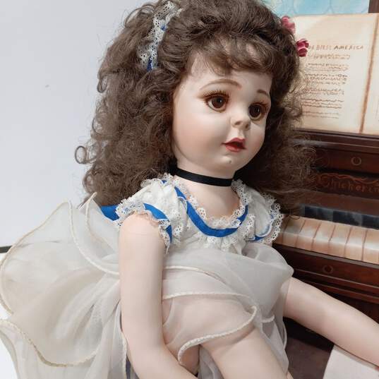 Vintage Doll Sitting On Bench Next To Piano image number 6