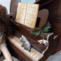 Vintage Doll Sitting On Bench Next To Piano image number 4
