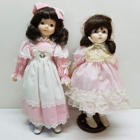 Lot of 2 vintage porcelain brown hair dolls in pink outfits image number 2