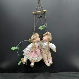 Porcelain Dolls Swinging in Wall Hanging Chair
